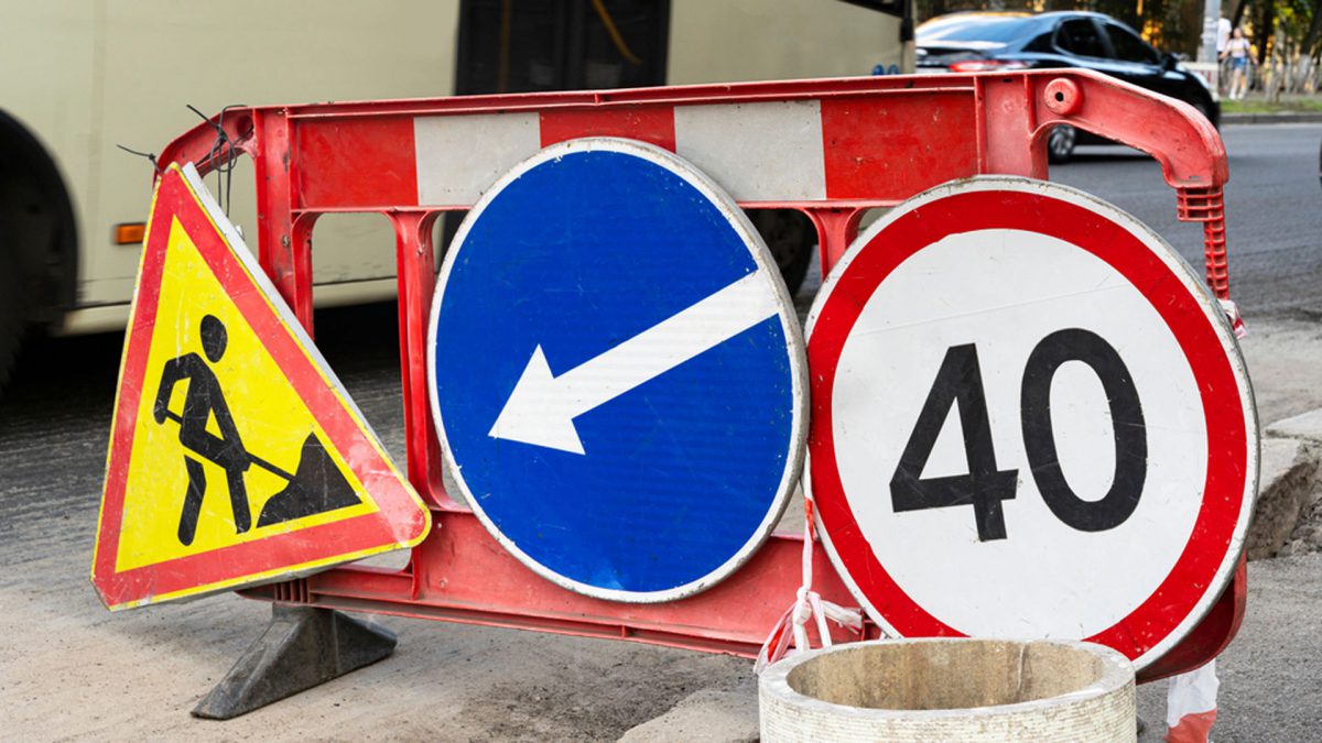 Repair of asphalt road surface. Road signs standing on the road being repaired